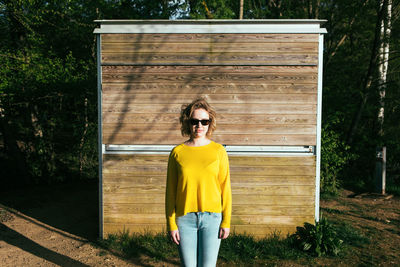 Portrait of man wearing sunglasses standing against plants