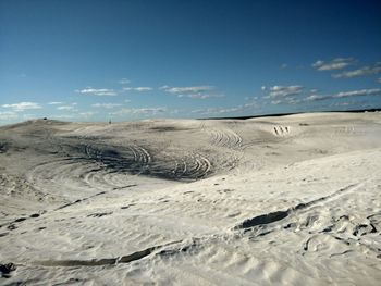 Scenic view of sand dunes against sky