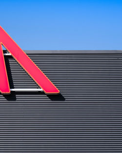 Low angle view of red flag against blue sky