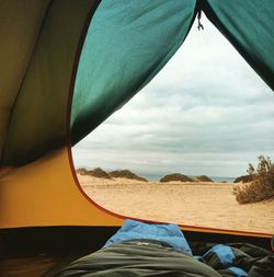 Cloudy sky over sea seen through tent