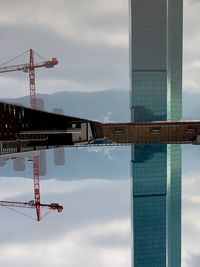Crane at construction site against sky