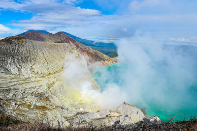 Smoke emitting from volcanic mountain against sky