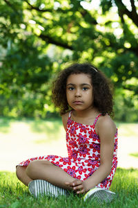 Portrait of young woman sitting on field