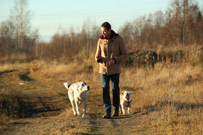 Full length of man with dogs walking on land