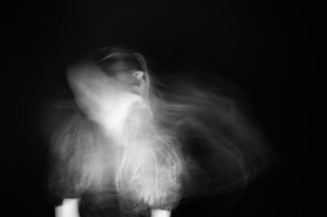 blurred motion, motion, black background, indoors, studio shot, one person, real people, adult, unrecognizable person, women, copy space, lifestyles, front view, three quarter length, leisure activity, domestic room, defocused, smoke - physical structure, hairstyle, digital composite