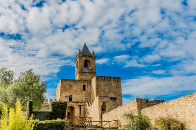 Tower with its bell tower and garden of the alcazaba castle in antequera, sunny day with a blue sky