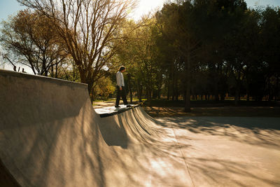 Side view of man standing by trees in park