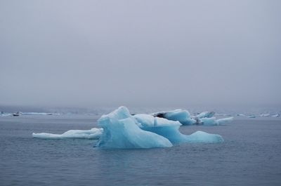 Ice floating on sea against sky