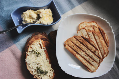 Sandwiches from a loaf and with cheese paste on a wooden stand and in a white plate