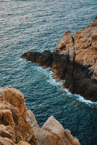 High angle view of rocks on sea shore