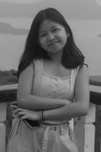 Portrait of young woman sitting at beach