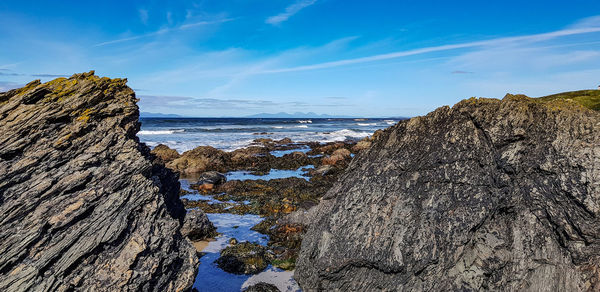 Rock formation on beach against sky