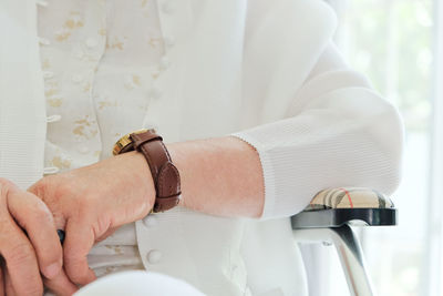 Midsection of woman sitting on chair at home