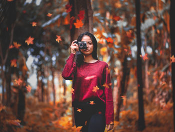 Woman standing by leaves during autumn
