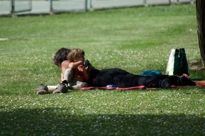 Side view of two lying resting on lawn