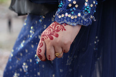 Midsection of bride hand with henna tattoo