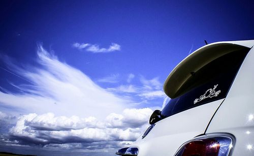 Cropped image of car against cloudy sky