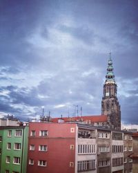 Low angle view of buildings against cloudy sky