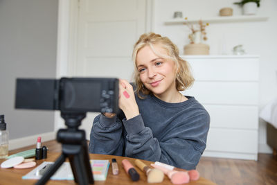 Portrait of young woman using mobile phone at home