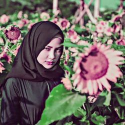 Portrait of woman with pink flower