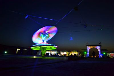 Illuminated lighting equipment on street against sky at night