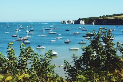 Boats in sea against clear sky