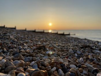 Stones on beach during sunset