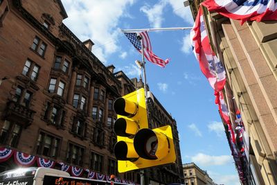 Low angle view of flags hanging against buildings in city