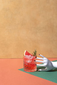 Cropped hand of woman holding christmas decoration on table