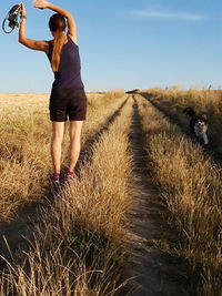 Rear view of woman on field against sky