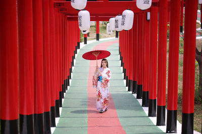 Woman standing by red outside building