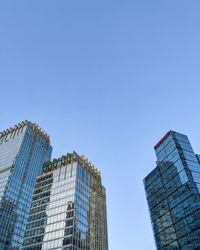 Low angle view of skyscraper against clear blue sky