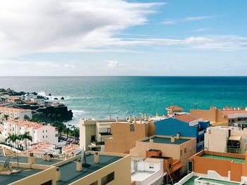 High angle view of townscape by sea against sky