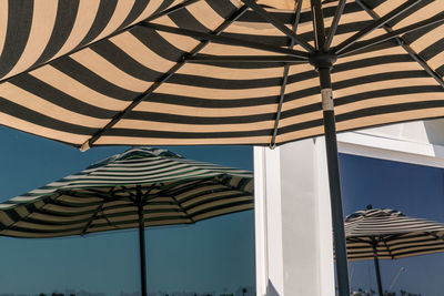 Low angle view of umbrella and its window reflection