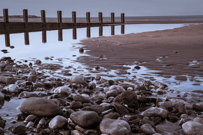 Wooden posts on beach