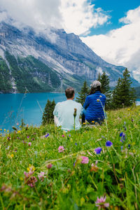 Rear view of people on mountain against sky