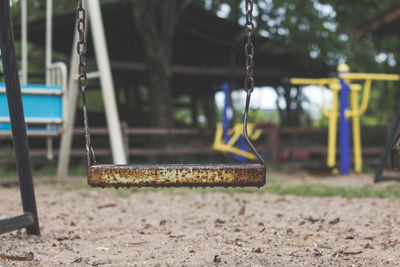 Wet rusty swing at playground during rainy season