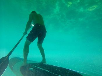 Full length of shirtless man swimming in sea