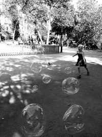 Full length of boy on bubbles in park