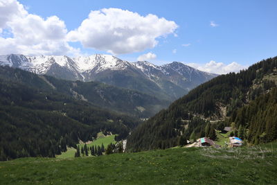 Scenic view of field and mountains against sky