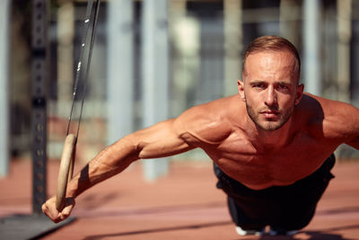 Portrait of young man exercising in gym