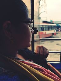 Side view of young woman sitting in bus