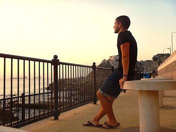 Man looking at sea while standing at observation point against sky