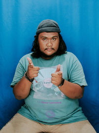 Portrait of young man sitting on sofa at home