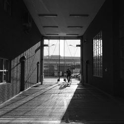 Rear view of people walking on street amidst buildings in city