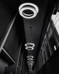 Low angle view of illuminated light fixture on ceiling of building