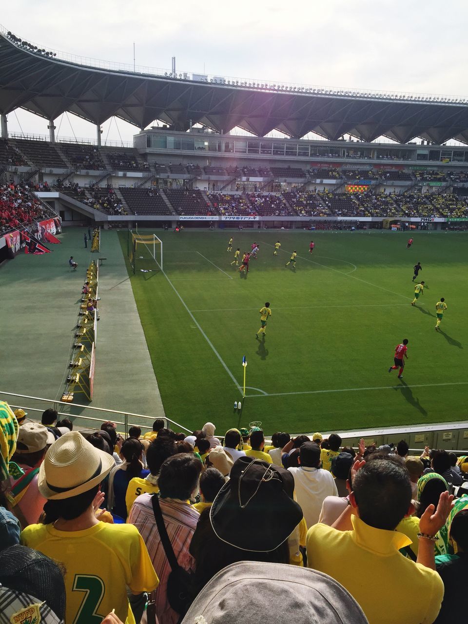 large group of people, leisure activity, crowd, high angle view, lifestyles, men, green color, stadium, sky, built structure, sport, person, arts culture and entertainment, landscape, grass, architecture, field, mixed age range, outdoors