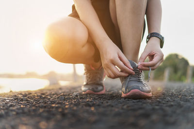 Low section of woman wearing shoes on land