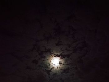 Low angle view of illuminated moon in sky at night