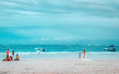People at beach against sky